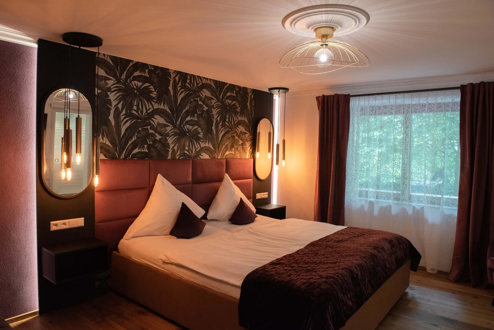 Superior Zimmer mit Doppelbett und floraler Wandgestaltung