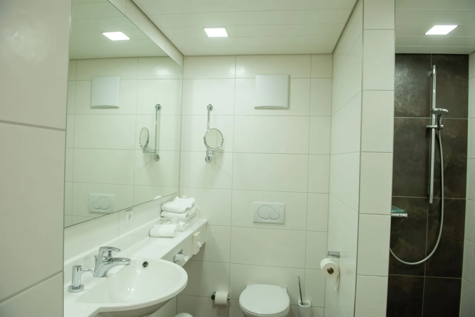 Bad der Junior Suite mit Waschbecken und ebenerdiger Dusche