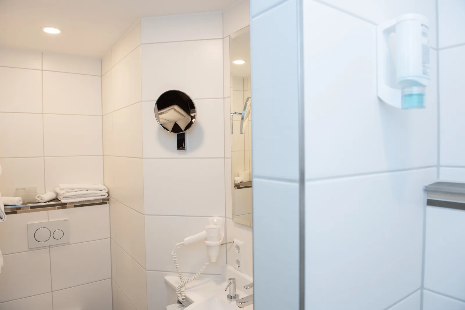 Helles Badezimmer mit Waschbecken und Kosmetikspiegel