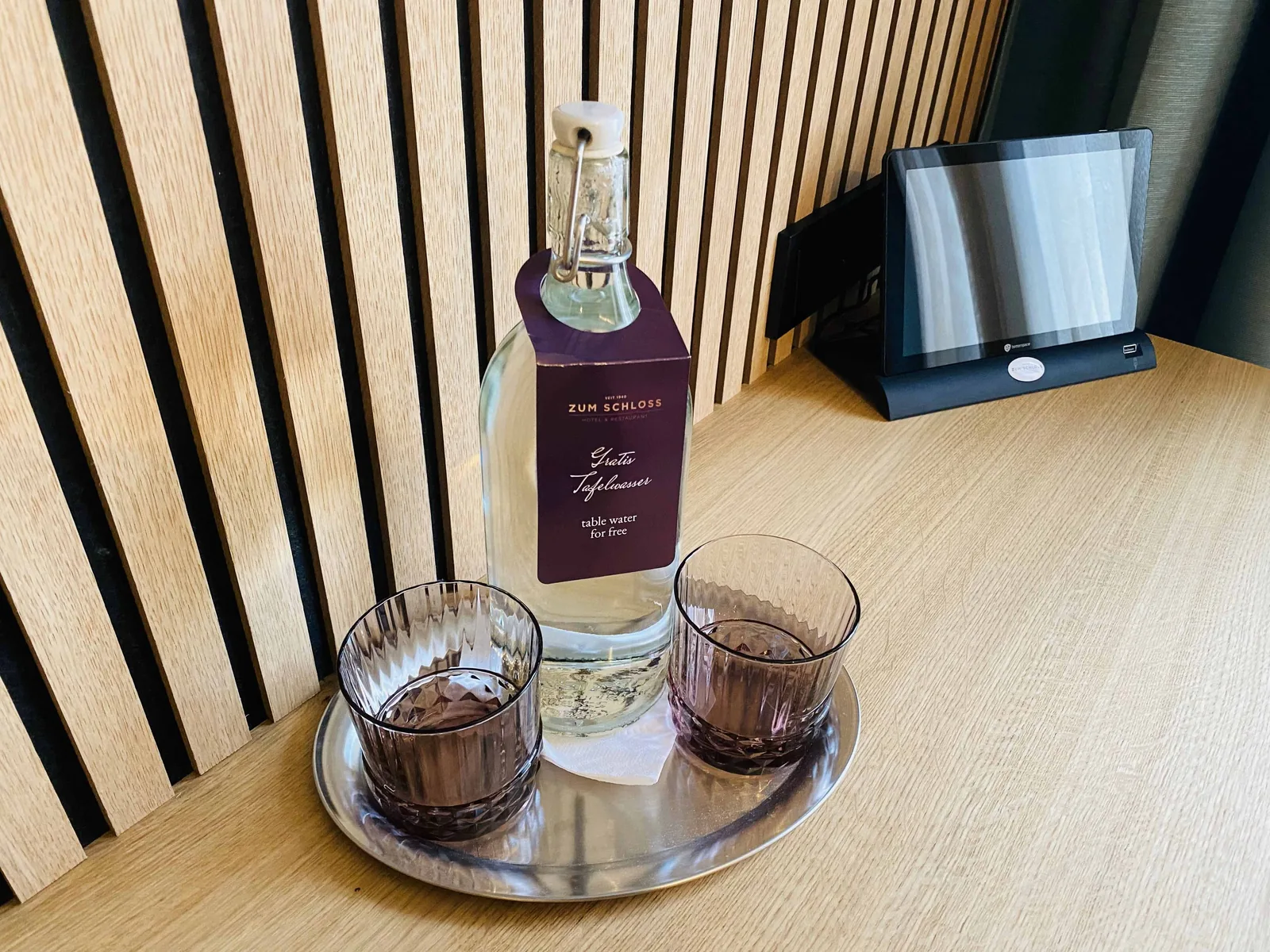Wasserflasche und kleine Gläser auf einem Tablett