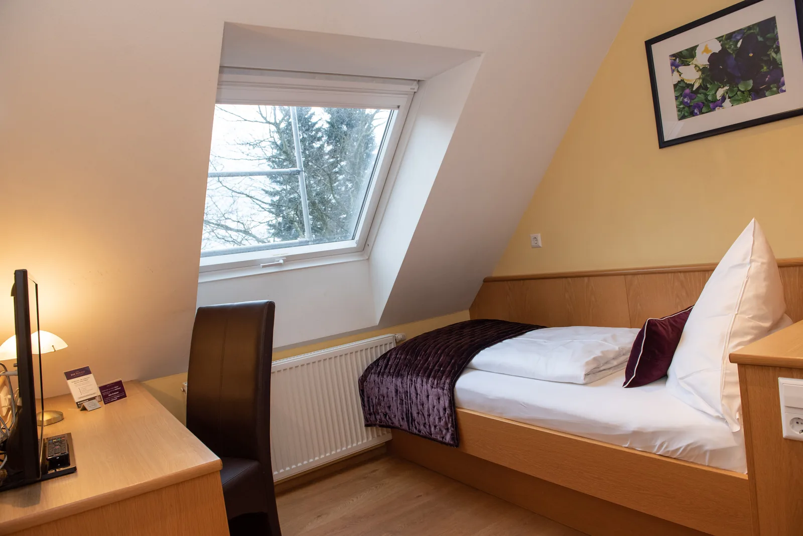 Einzelzimmer mit Einzelbett unter der Dachschräge
