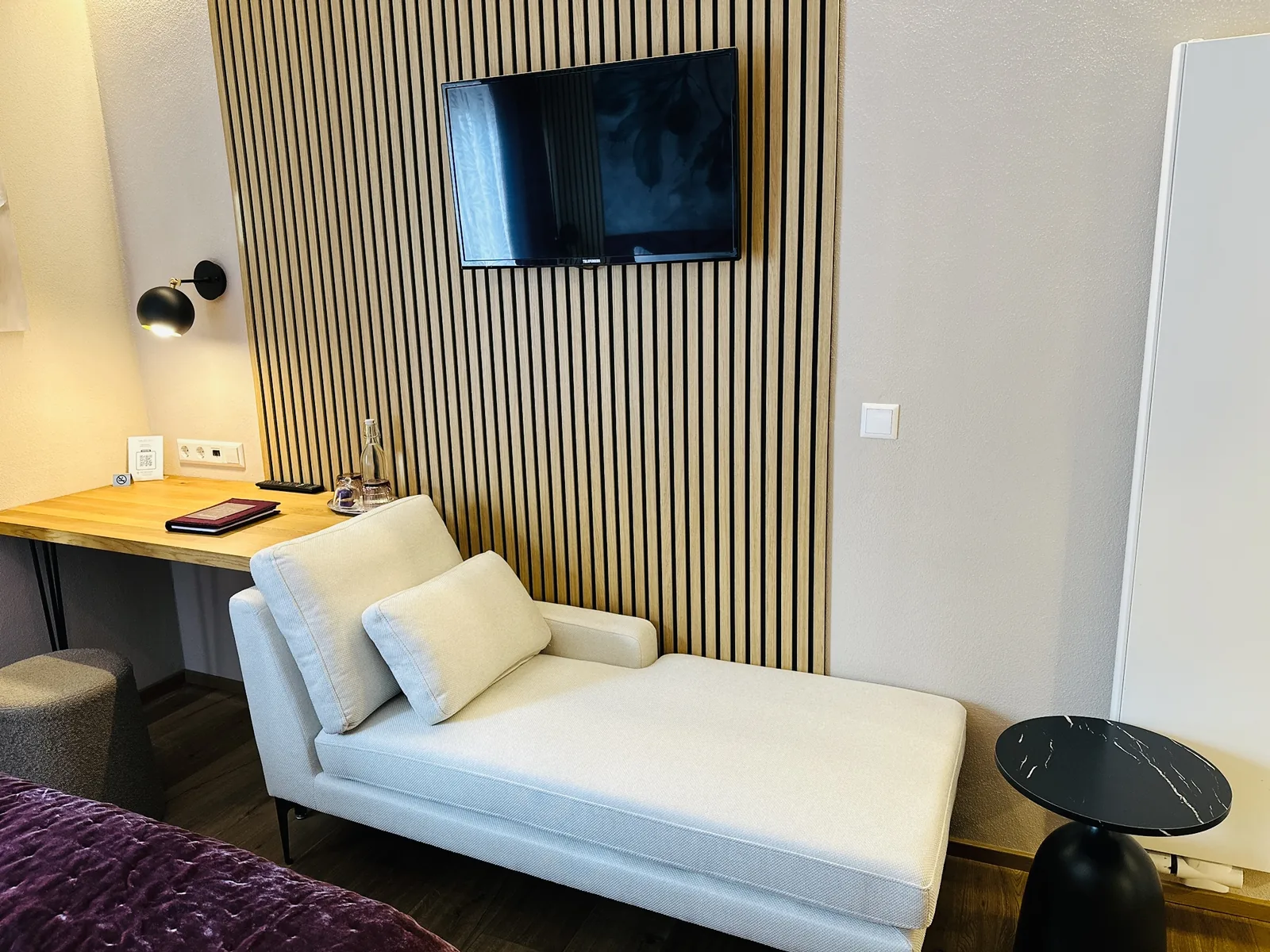 Helle Chaiselongue unter dem Fernseher im Komfortzimmer