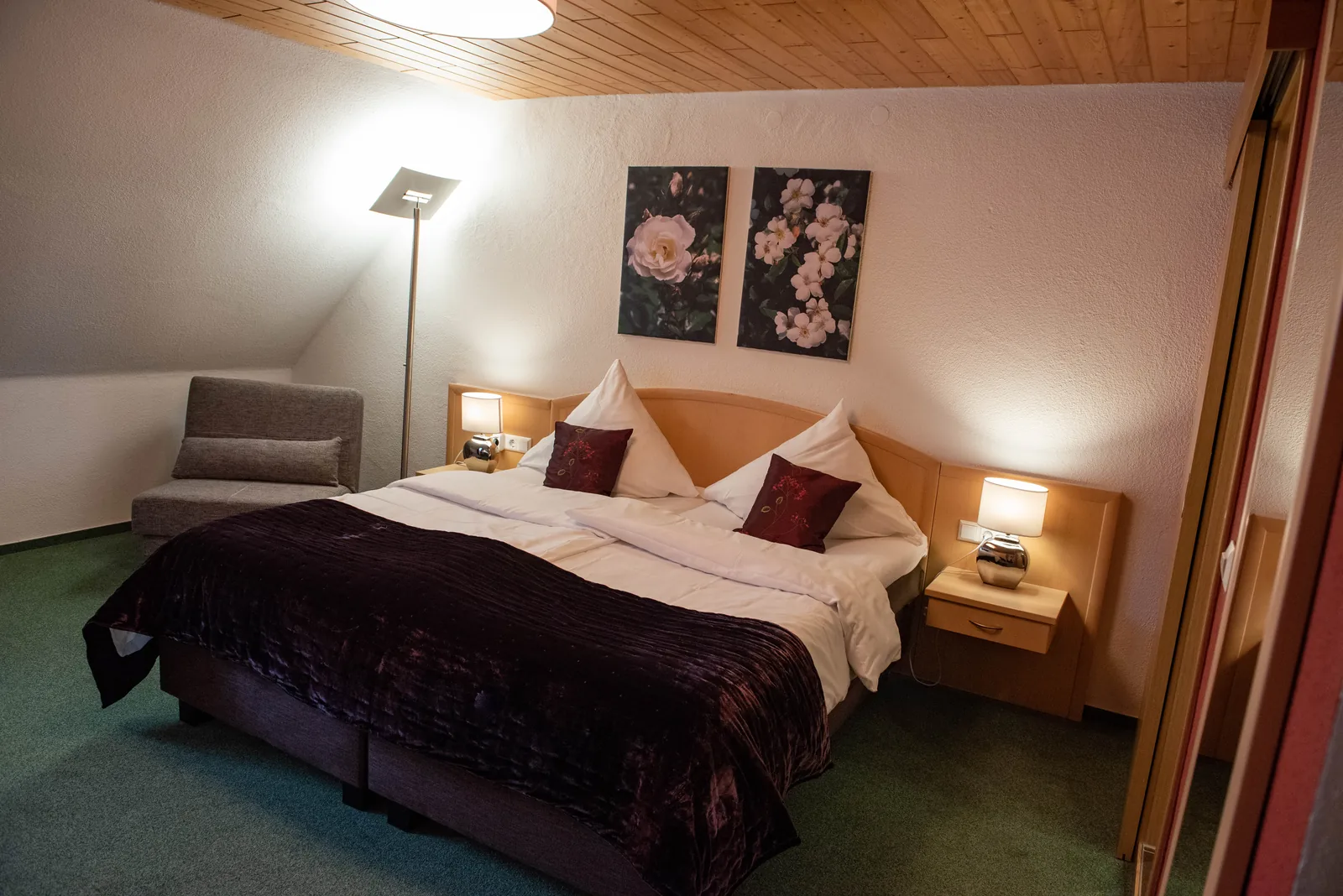 Gasthofzimmer mit Doppelbett, Sofa und Teppichboden