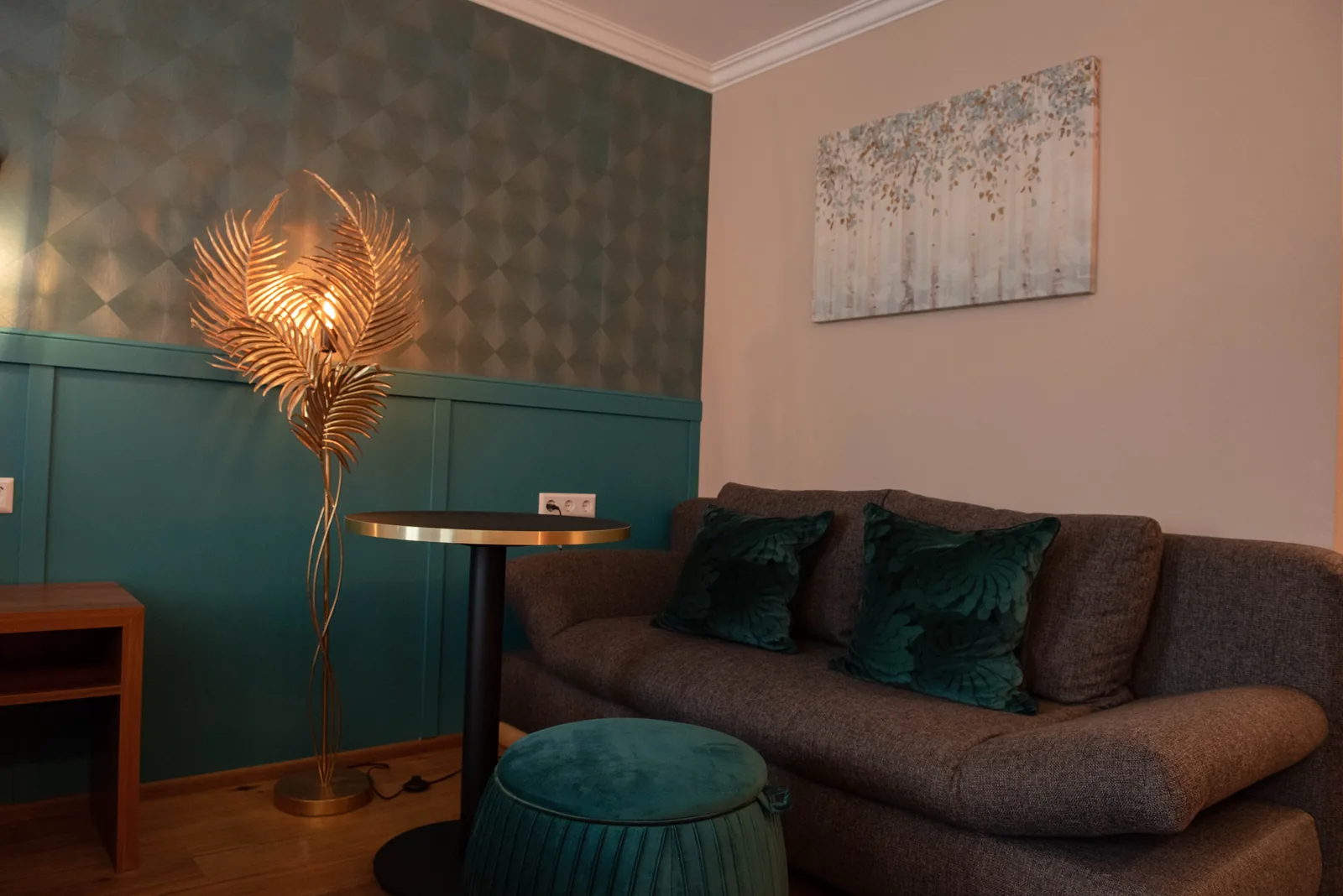 Sofa und Dekoration vor türkisfarbener Wand im Superior Zimmer
