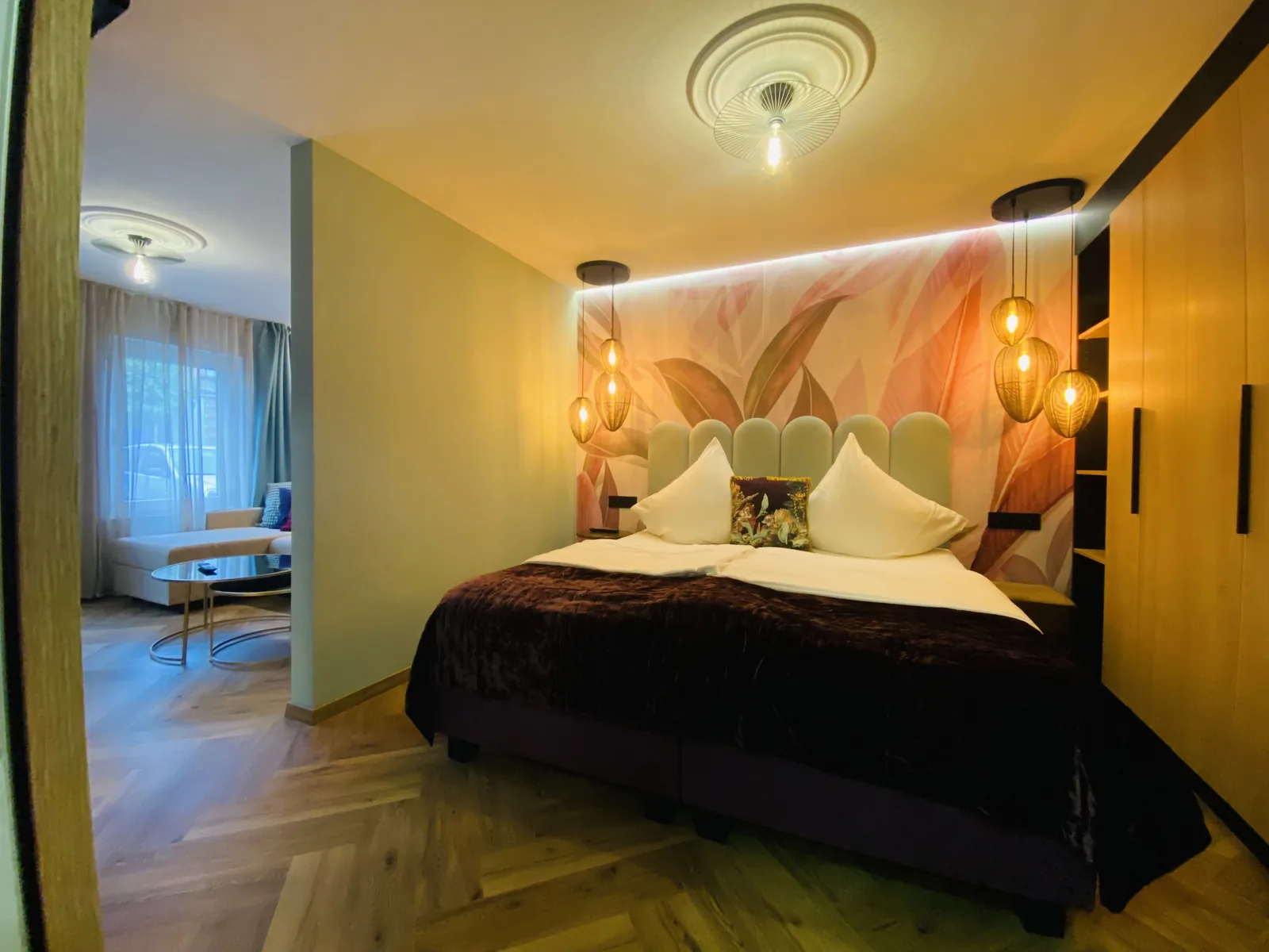 Schlafbereich der Junior Suite mit Doppelbett und Floraltapete