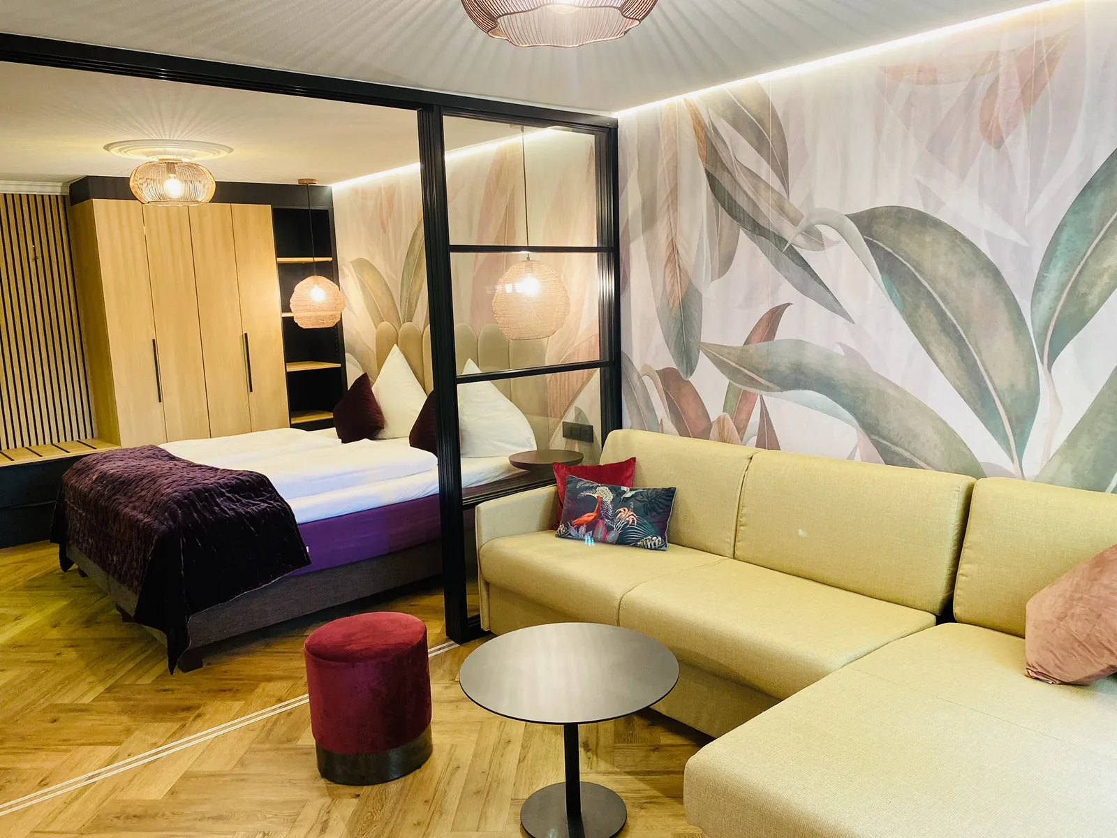 Wohnbereich der Junior Suite mit Ecksofa und Glasschiebewand