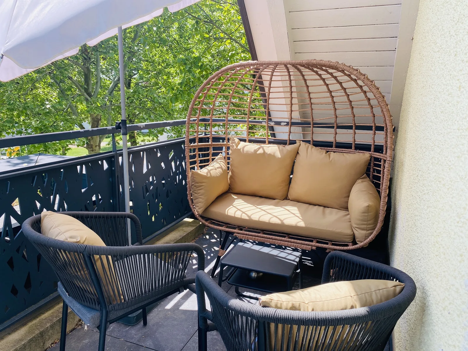 Südbalkon mit Korbsessel und Blick ins Grüne
