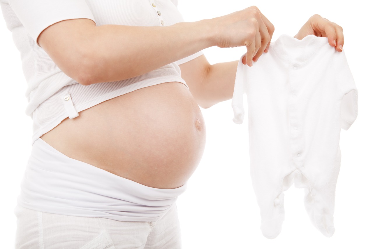 Schwangere Frau mit baby strampler