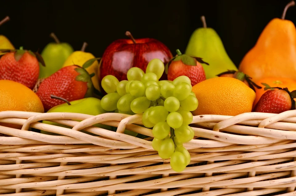 Korb mit Obstsorten wie Apfel, Birne, Orange, Trauben