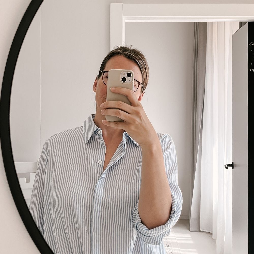 Spiegel-Selfie einer Frau, das Handy verdeckt ihr Gesicht