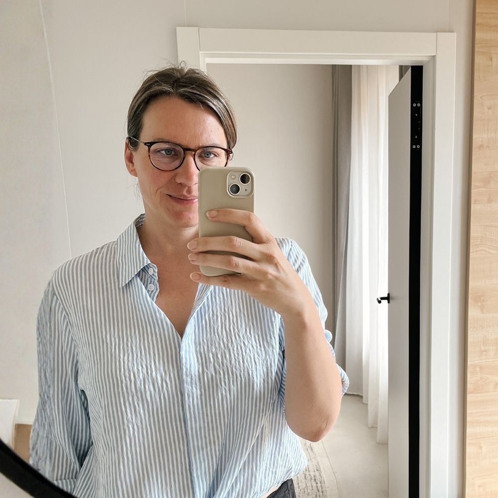 Spiegel-Selfie derselben Frau, diesmal ist ihr Gesicht zu sehen