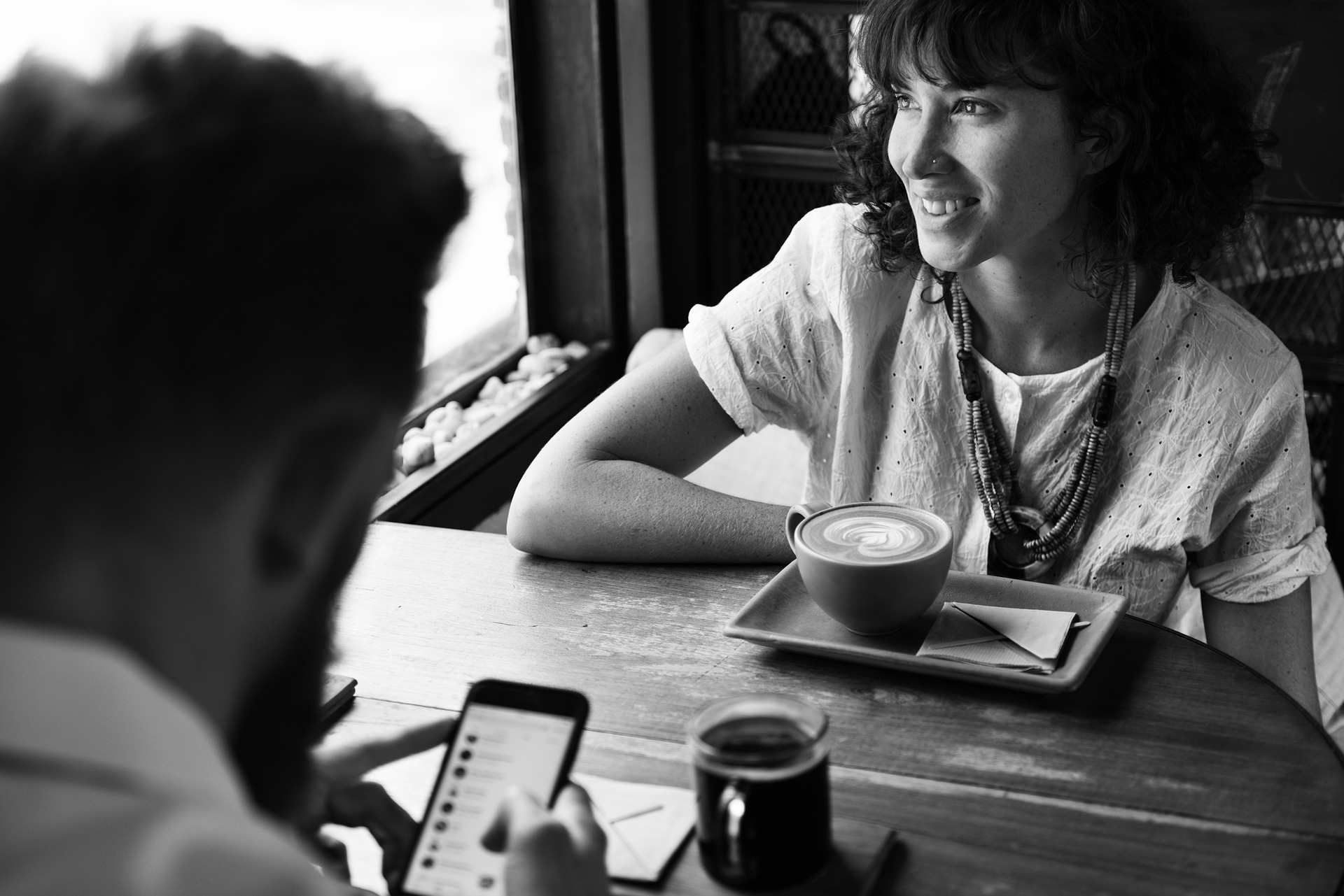 Mann benutzt Smartphone beim Flirten