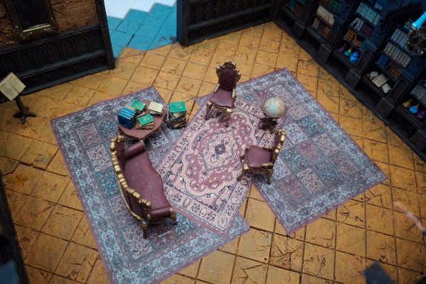 Miniatur-Salon mit Teppich, Sofa, Globus und Bücherstapel