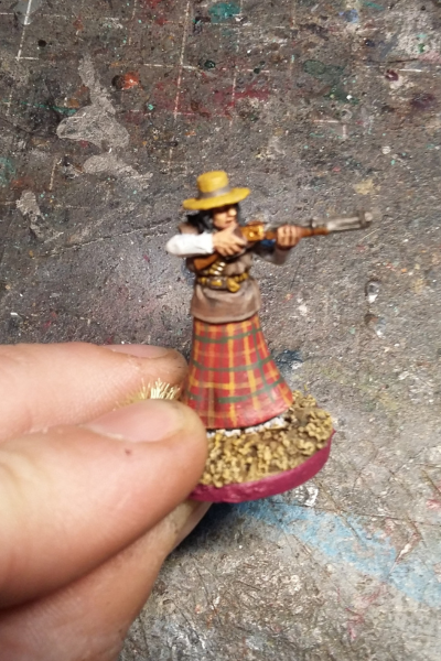 Miniatur einer bewaffneten Westernfrau mit Gewehr und kariertem Rock – handbemalt“