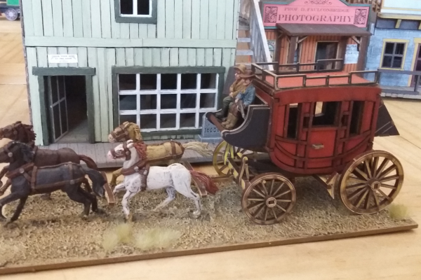 Miniatur-Kutsche mit Cowboy-Fahrer und vier Pferden in Westernstadt – handbemalt