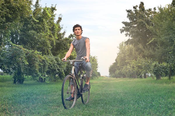 Fahrradfahrer zwischen Obstbäumen auf der Wiese