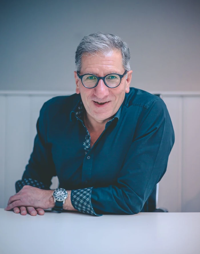 Martin Matheo Doeller von Sinnstory sitzt auf einem Tisch