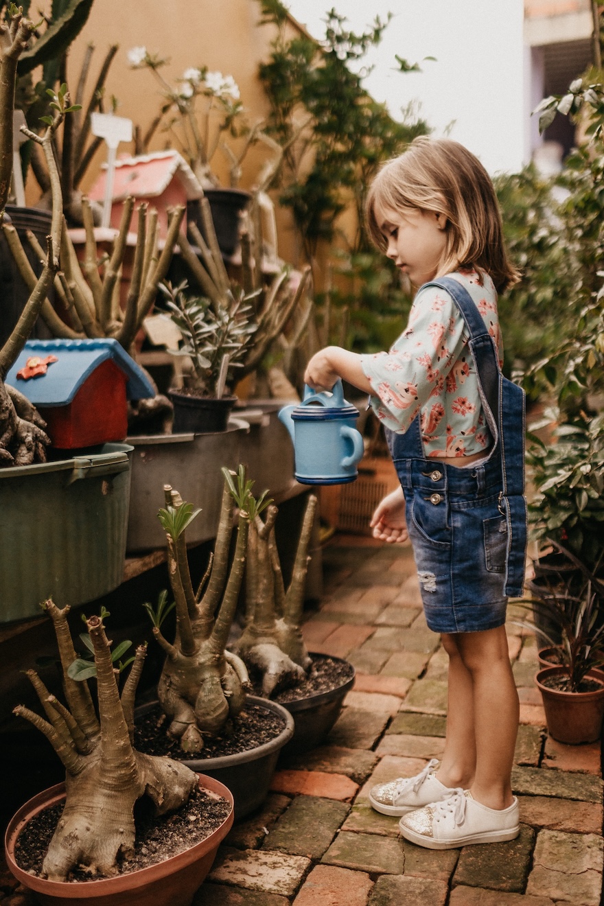 alt:"Photo by Jonathan Borba on Unsplash" Title:"Mädchen kümmert sich um Pflanzen"