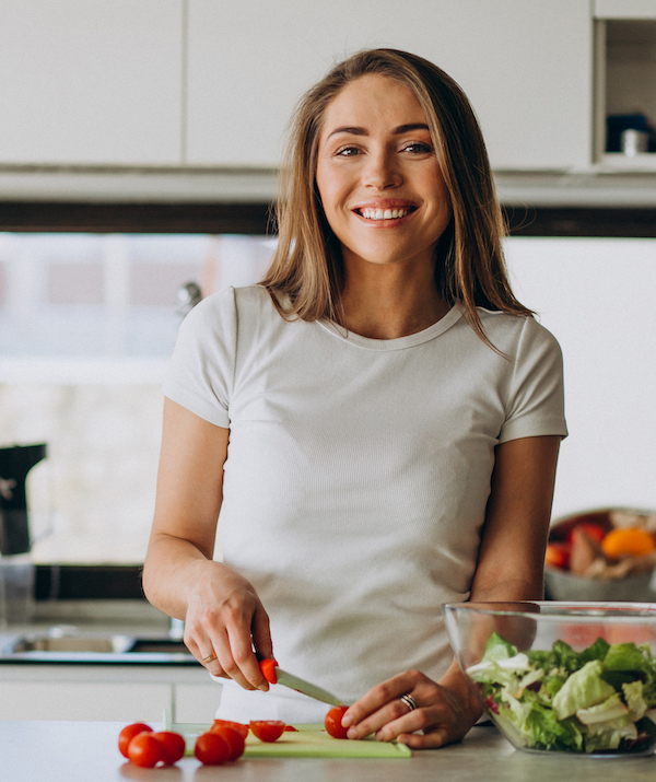 Junge Frau macht einen Salat zur gesunden Ernährung durch Hormone Leptin