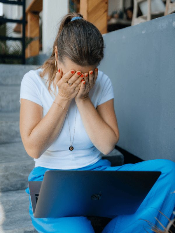 Studentin hält sich die Hände vors Gesicht