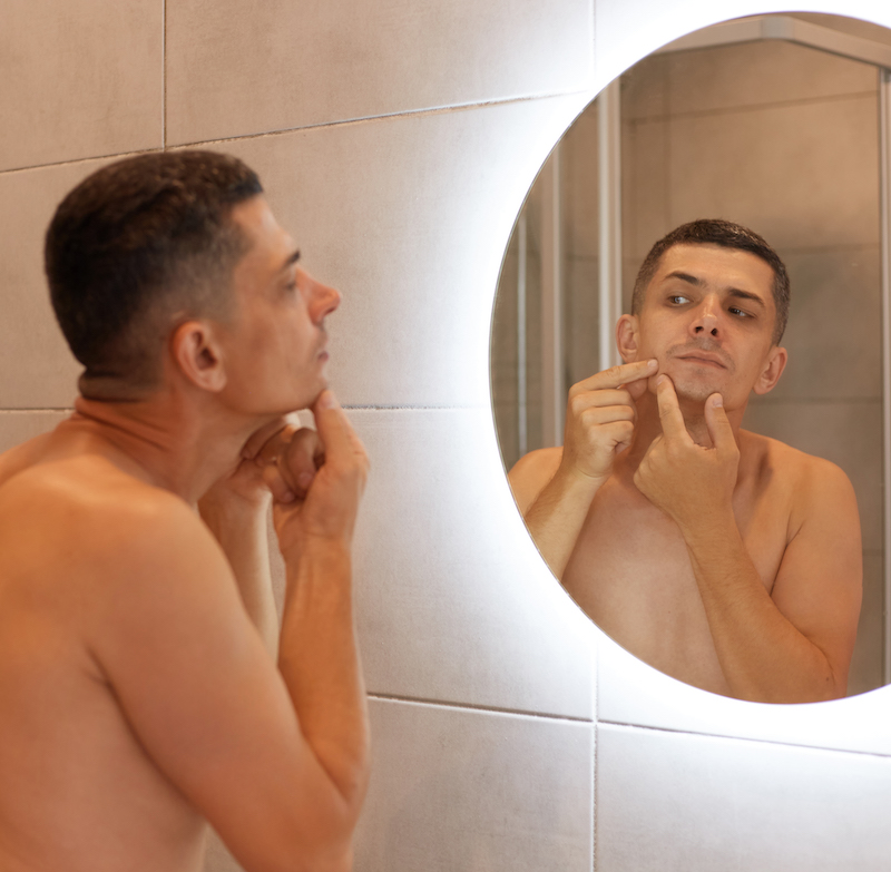 Spiegel Reflexion Mann mit schwarzen Haaren morgen Hygiene Pickel ausdrücken