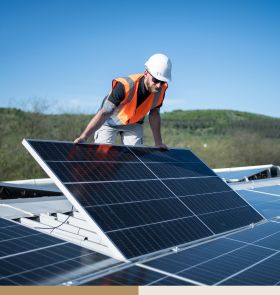 Mann installiert Photovoltaik auf Dach