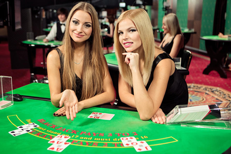 zwei frauen an blackjack tisch in online casino geben karten aus