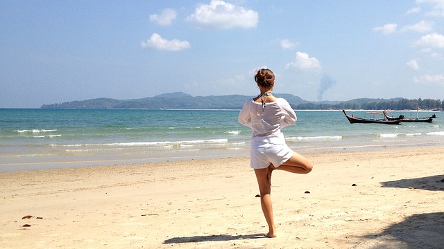 Frau in Yogaposistion am Strand