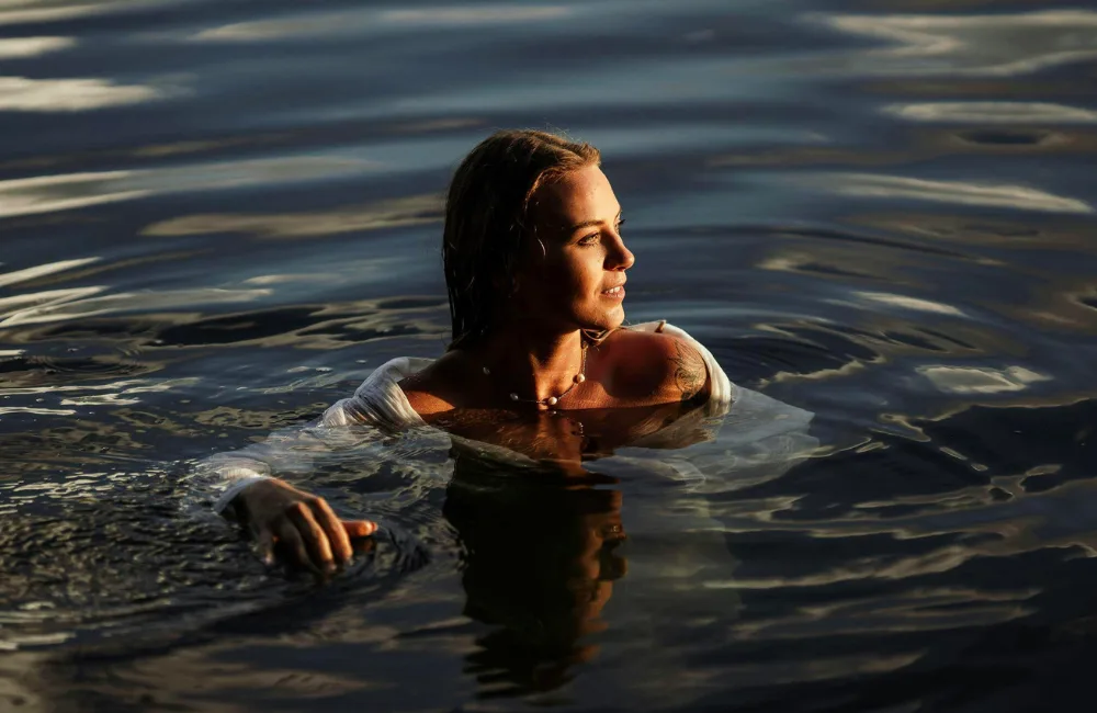 Frau im Meer im Abendlicht