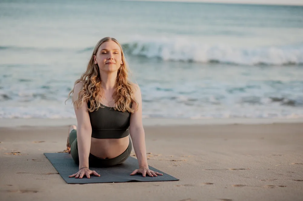 Luisa in Yoga-Haltung am Strand