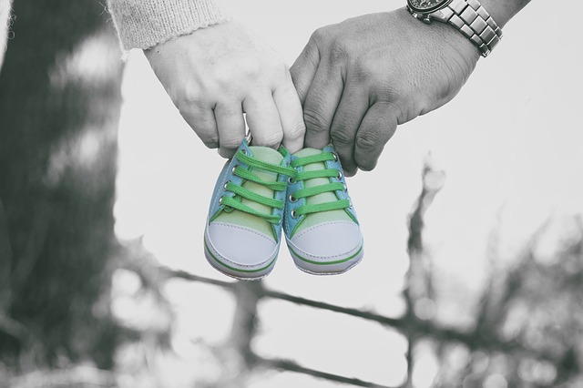 Mann und Frau halten Baby Schuhe