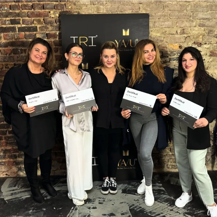 Teilnehmerinnen der IRI® Filler-System Schulung mit ihren Zertifikaten vor der YAVU® Fotowand